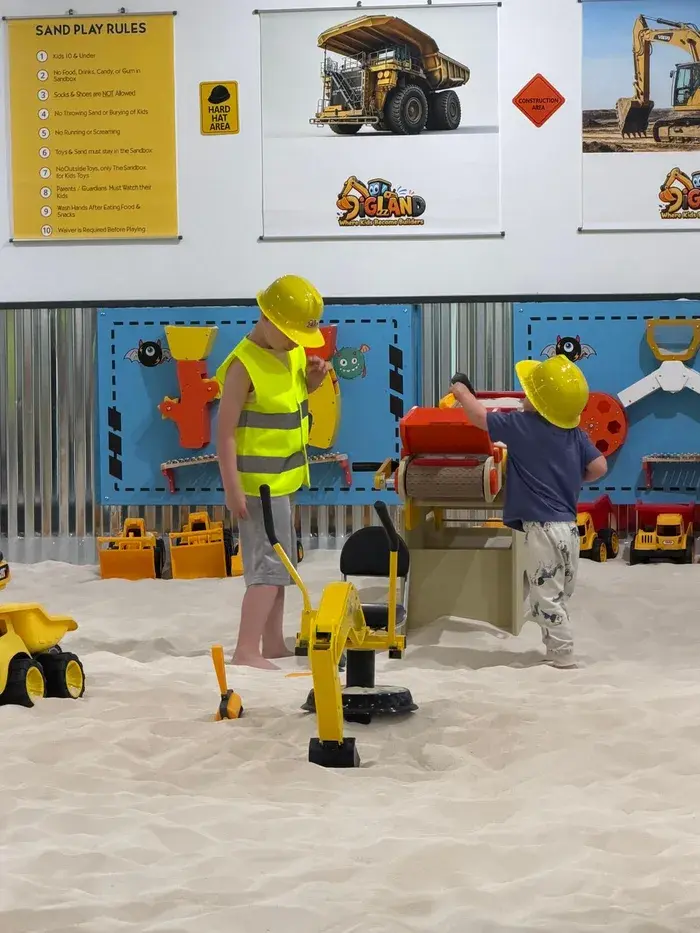 A child building their own world in the sand with construction toys