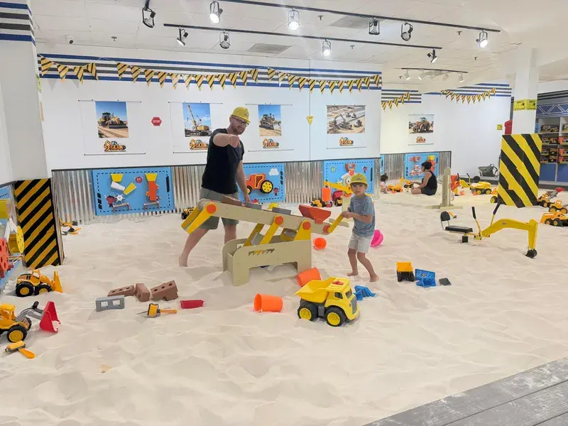 Children stacking blocks beside the sand table