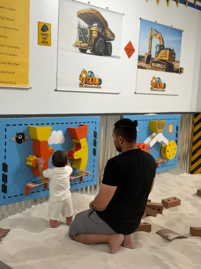 A parent and toddler exploring the activity wall together