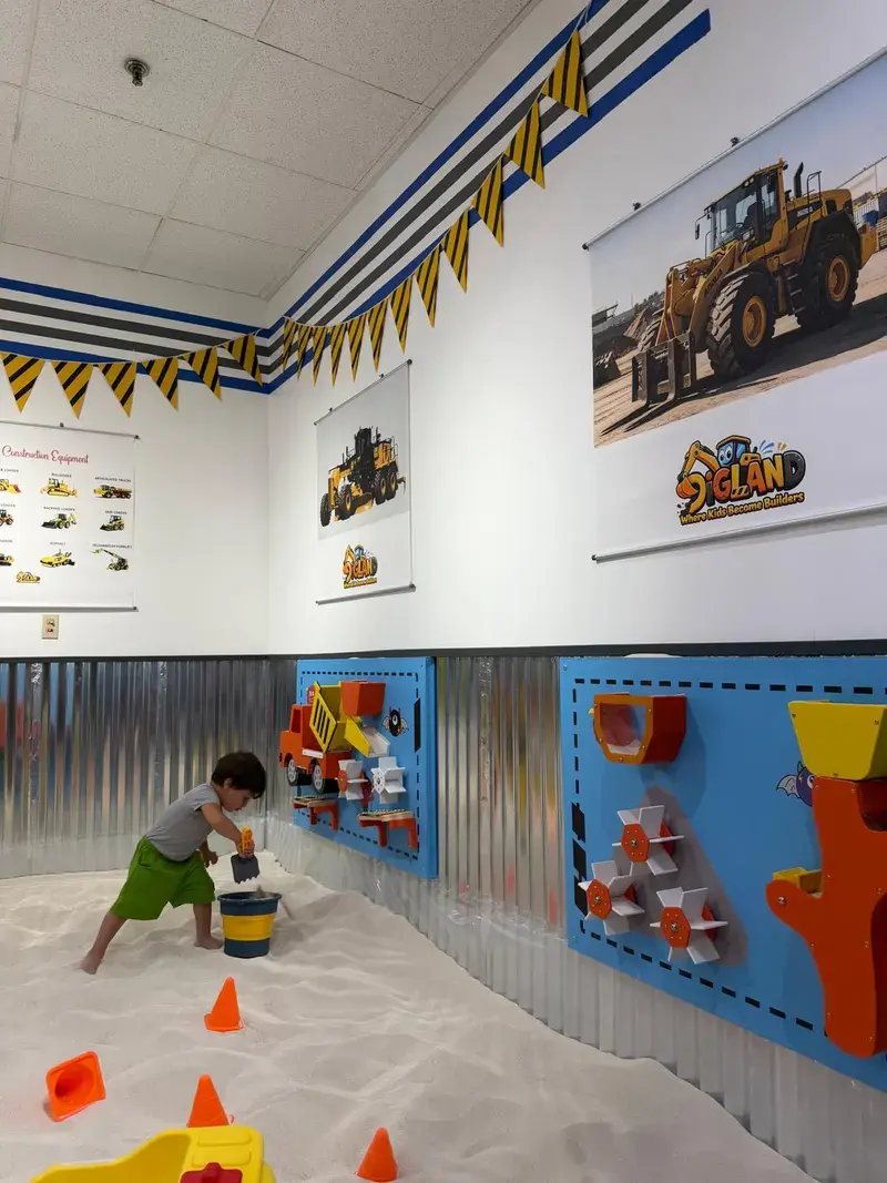 Child exploring the activity wall with a bucket